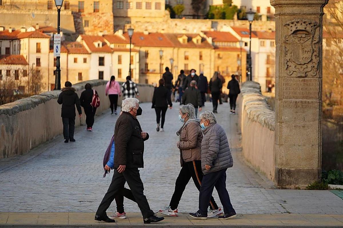 Varias personas mayores pasean junto al Puente Romano, una de las principales recomendaciones de los expertos.