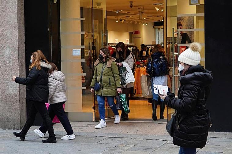 Clientes salen de un establecimiento de ropa de Salamanca.