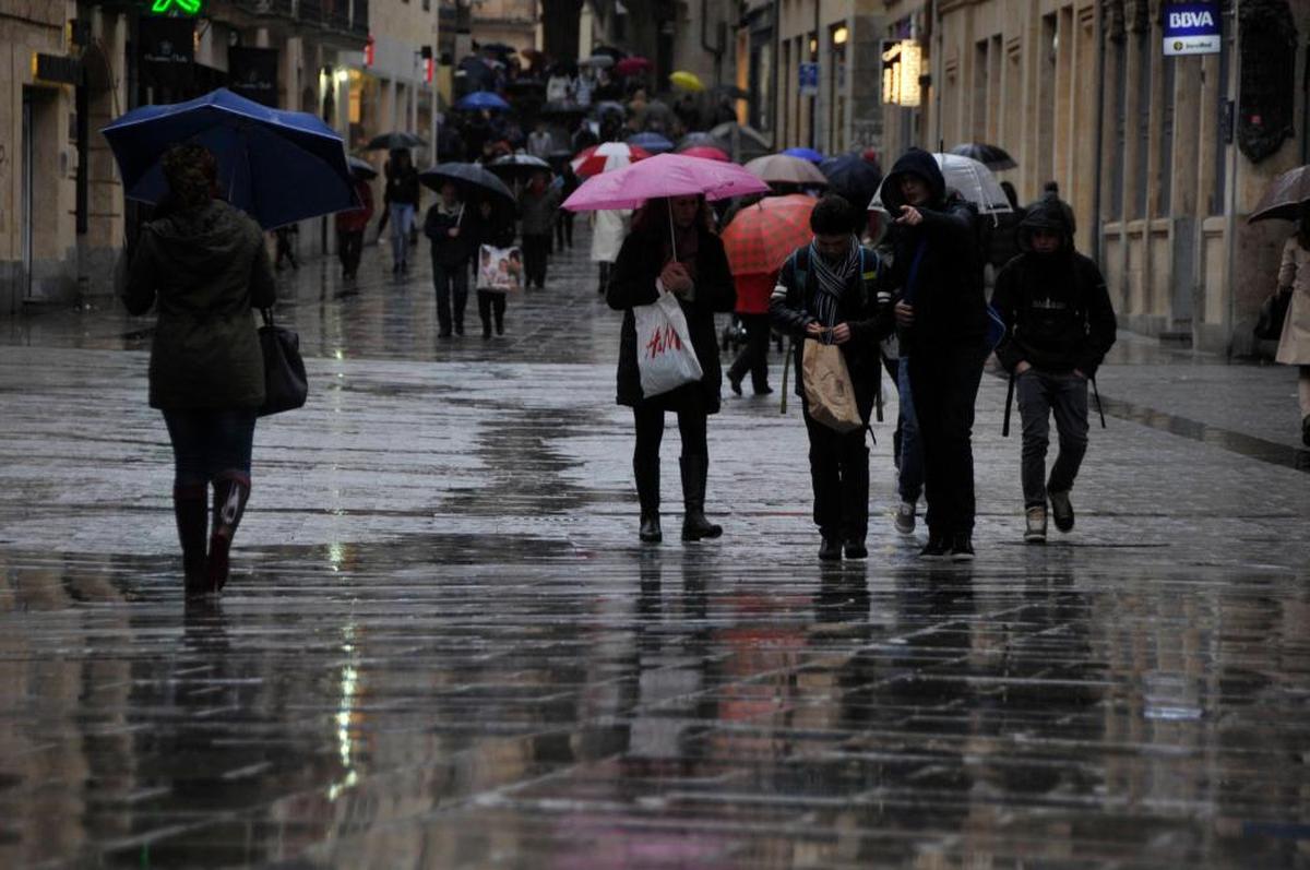 Varias personas por la calle Toro de Salamanca mientras llueve.