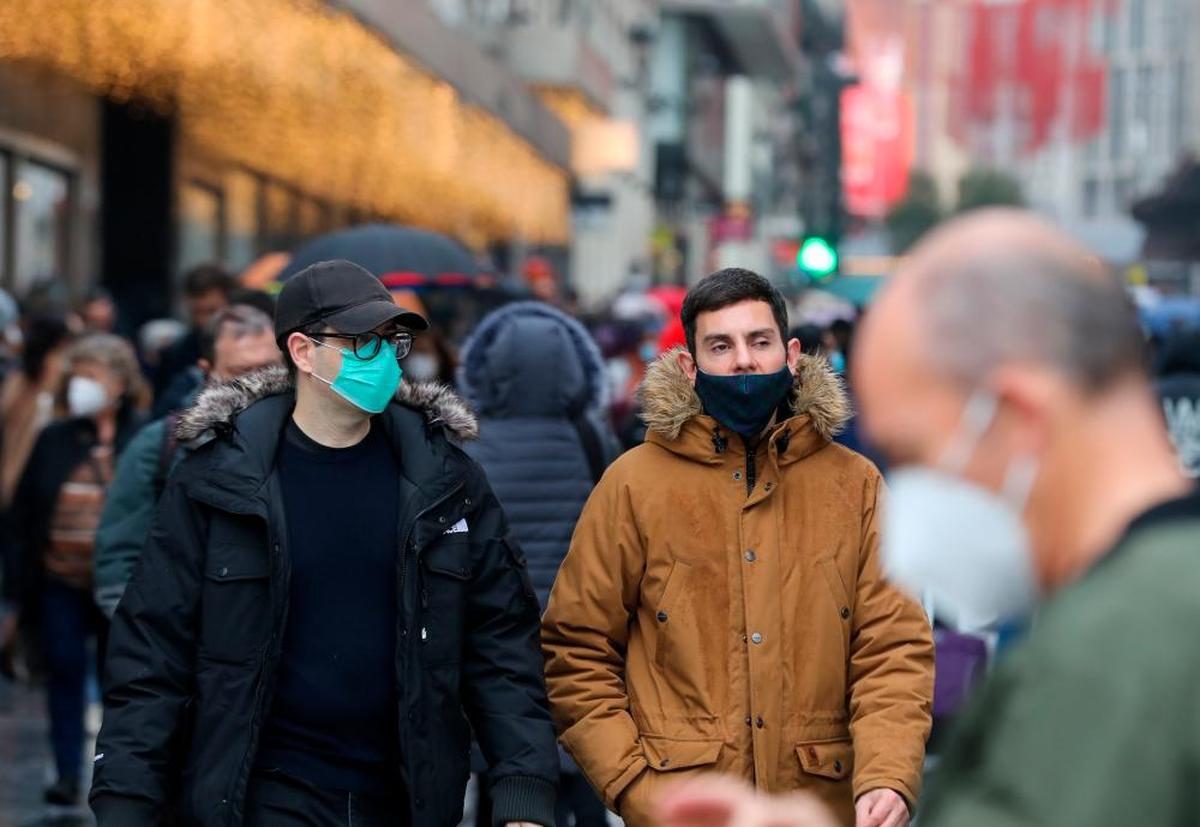 Varias personas pasean con la mascarilla puesta.