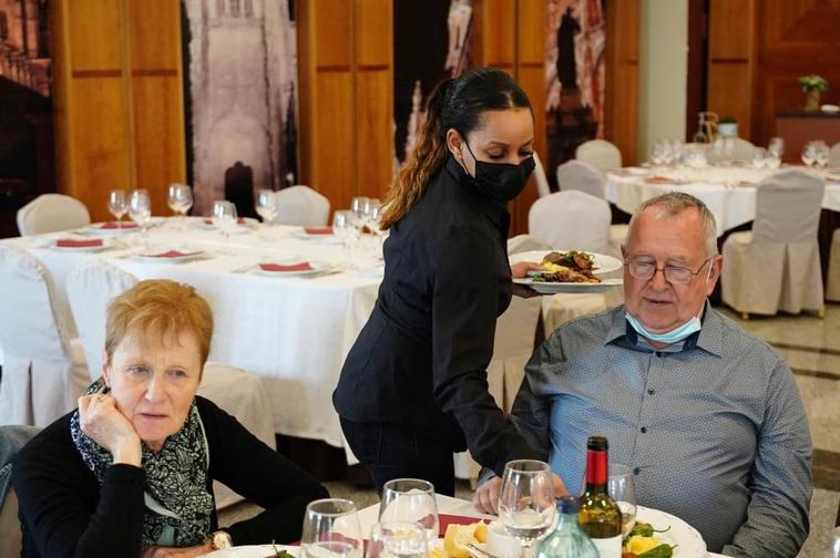 Una camarera sirve a un comensal en el salón de un restaurante de Salamanca.