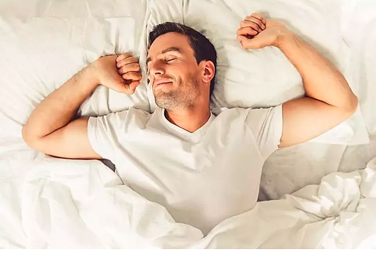 Un hombre se estira en la cama tras un reparador sueño