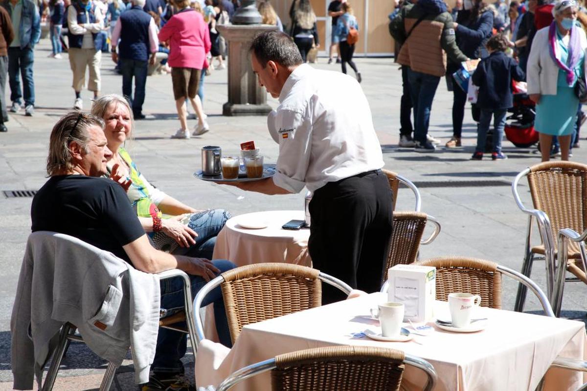 Un camarero sirviendo a unos clientes en una terraza