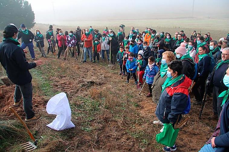 Parte de los participantes en la plantación del nuevo bosque municipal de Aldeatejada, atentos a las instrucciones de plantado.