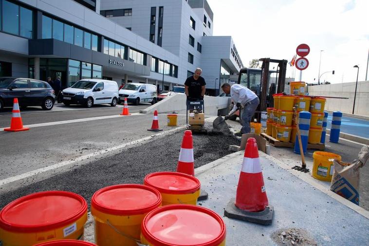 Dos operarios trabajan en los accesos del parking del nuevo Hospital para que sea más fácil maniobrar.