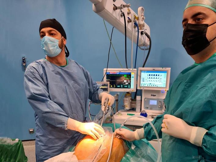 Dos profesionales sanitarios realizan una intervención en el Hospital General Santísima Trinidad.