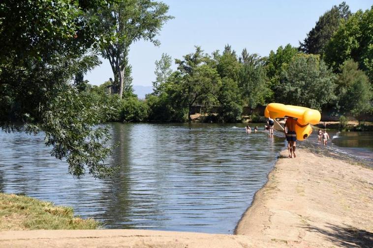 Bañistas disfrutan en la tarde de ayer de la zona de La Pesquera del río Águeda a su paso por Miróbriga.