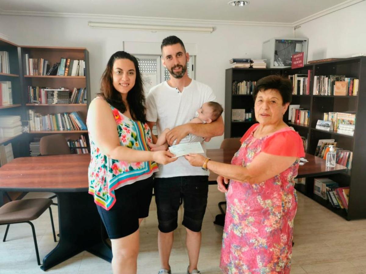 Los padres de Hugo, Sandra y Cristina, reciben el cheque de manos de la concejala Flora Antonia Pérez.