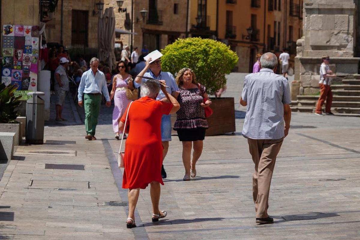 Un grupo de personas pasean por la calle durante la ola de calor