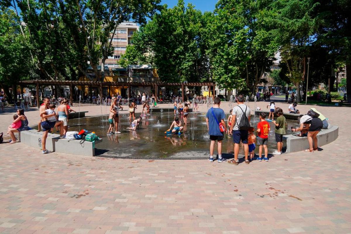 Niños se refrescan en la fuente de la Alamedilla.