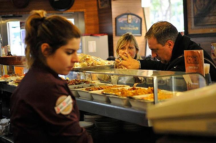 Una joven trabajando como camarera en un bar.