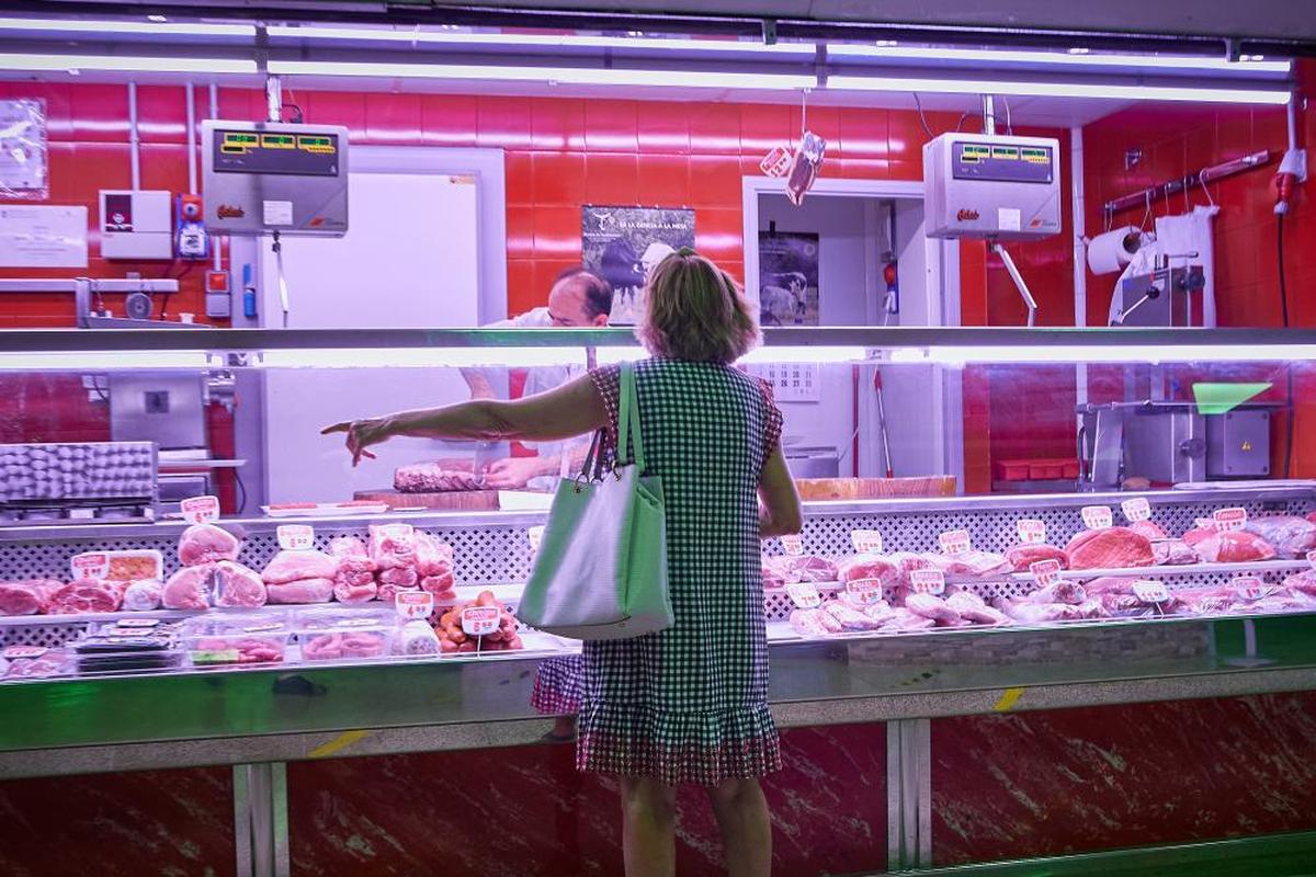 Una mujer compra en una carnicería de un mercado madrileño.