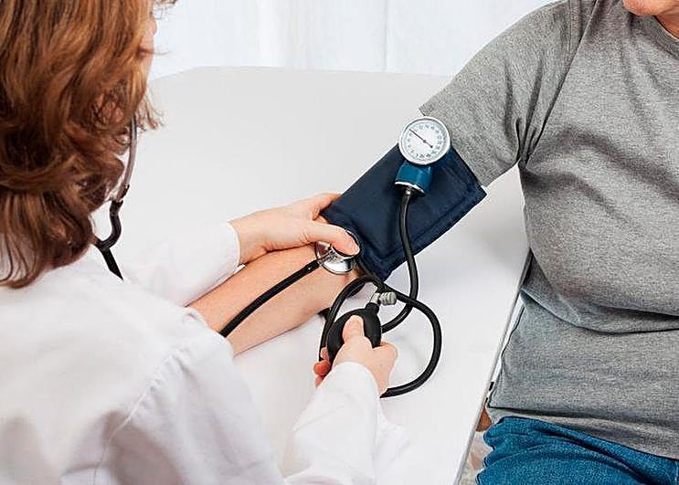 Una paciente midiéndose la tensión