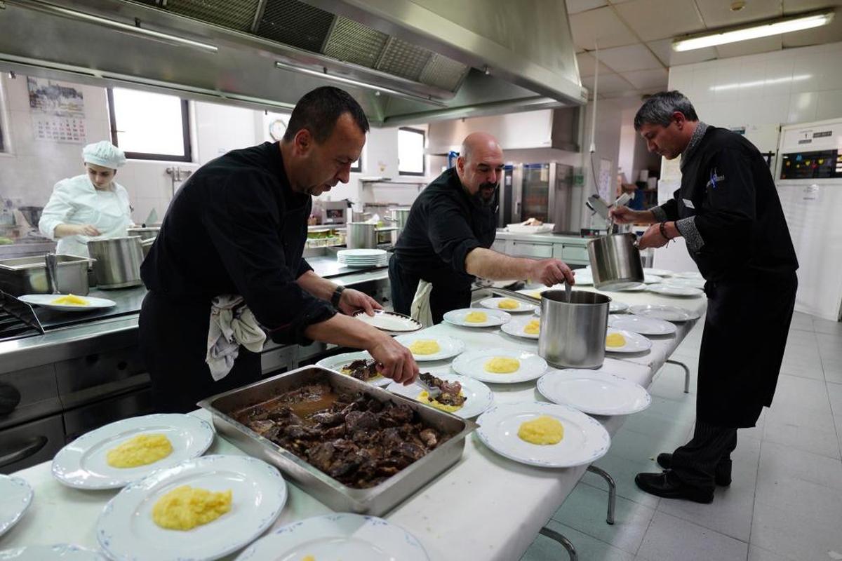 Camareros y cocineros preparando los platos antes de salir hacia la sala.