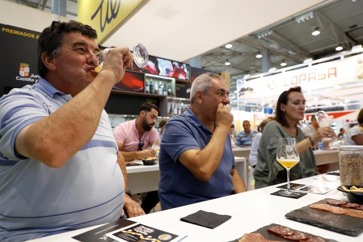 Varias personas almuerzan embutido y beben cerveza de manera gratuita en los stands.