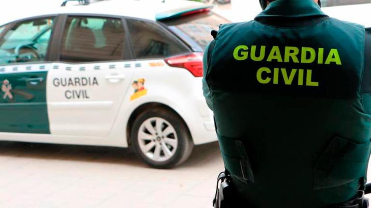 Un agente de Guardia Civil junto a un coche