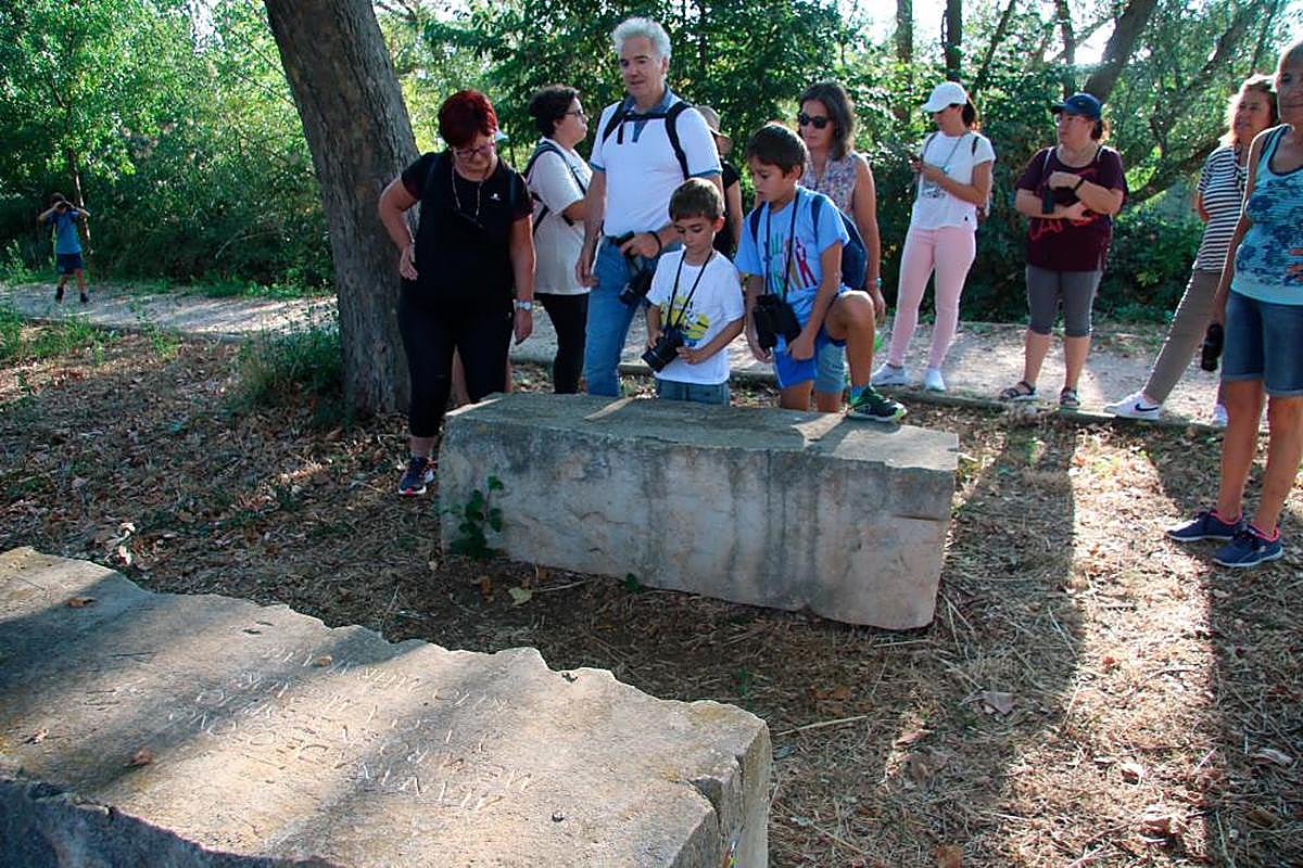 Un grupo de participantes en la ruta natural viendo los poemas.