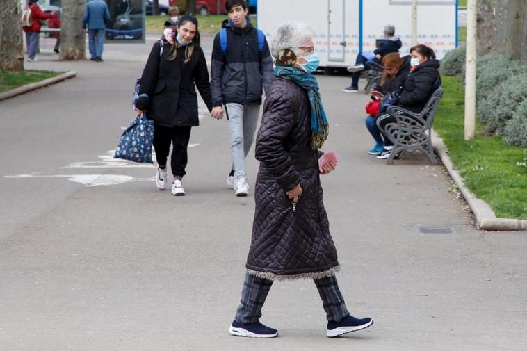 Una mujer pasea abrigada por el parque ‘La Alamedilla’.