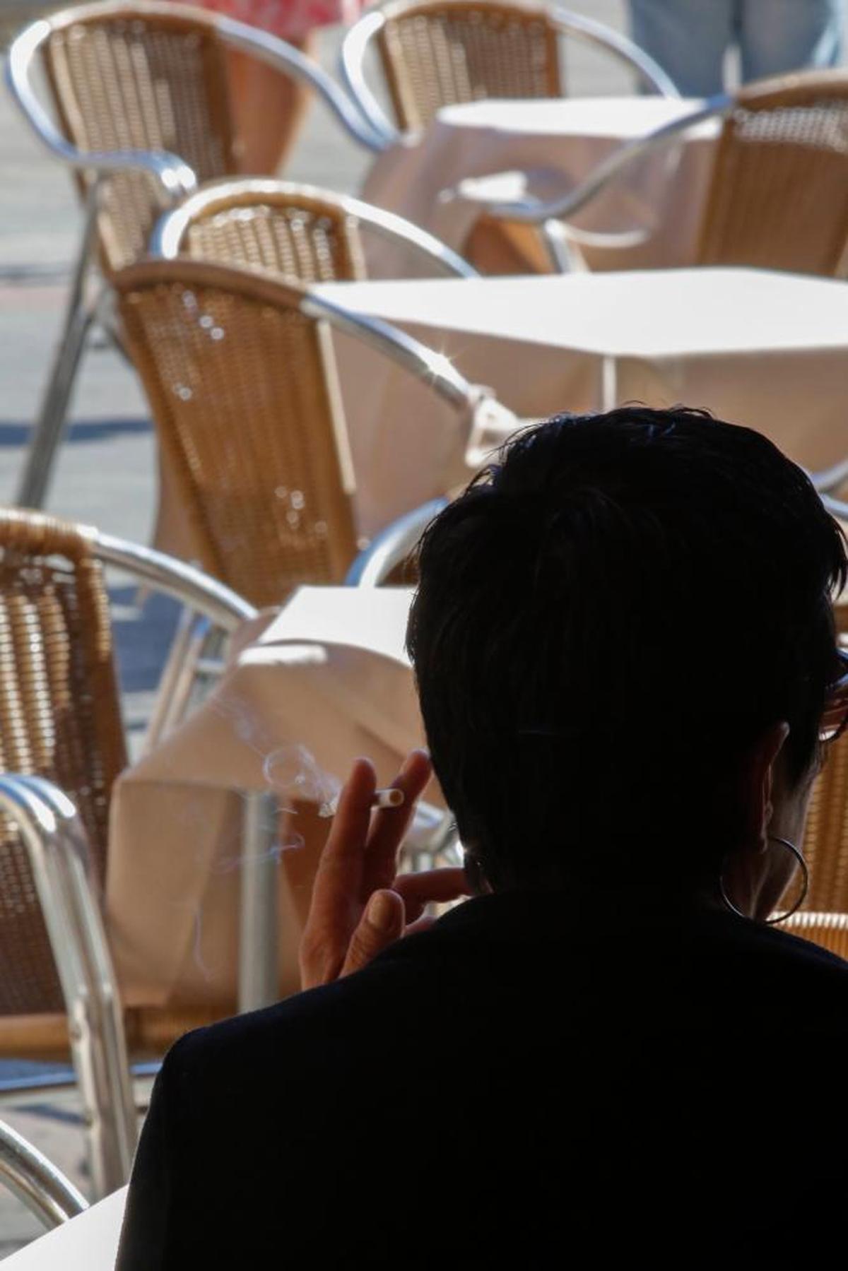 Una persona fuma en una terraza de la Plaza Mayor de Salamanca.