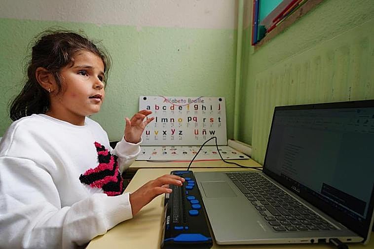 Carlota Corredera, alumna de primero de Primaria, escribe con una ‘línea braille’ conectada a un ordenador portátil.