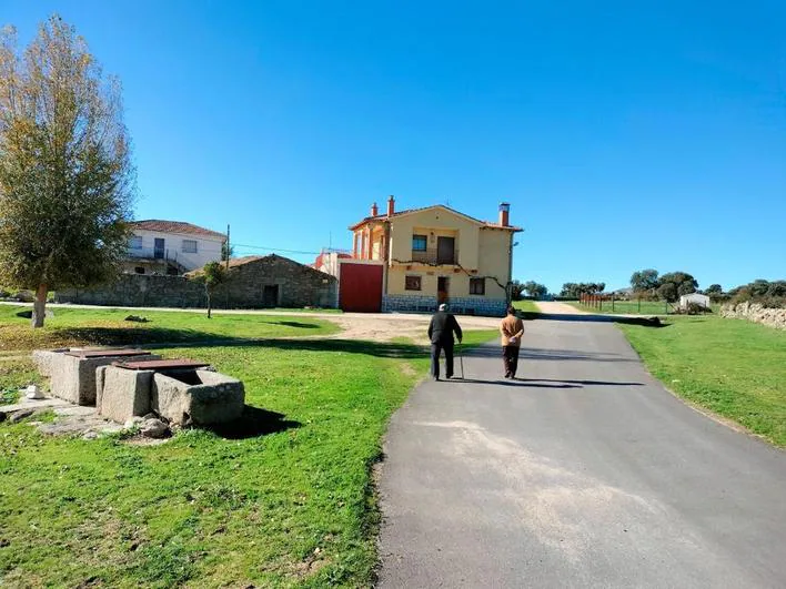 Dos vecinos caminando ayer por una calle de Navamorales