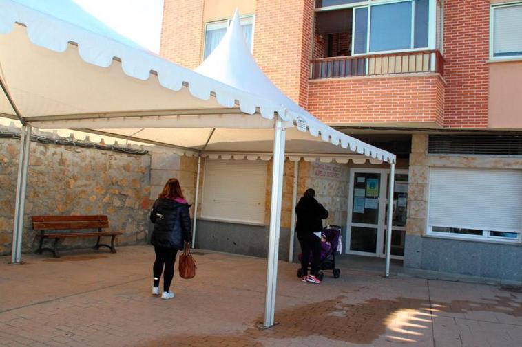 Dos vecinos esperan en la entrada del actual consultorio médico de Villamayor de Armuña