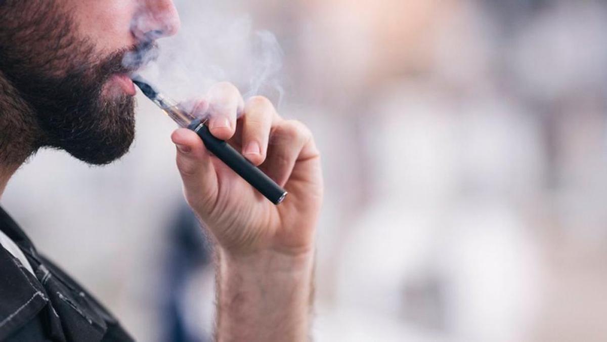 Un hombre utiliza una vapeador.