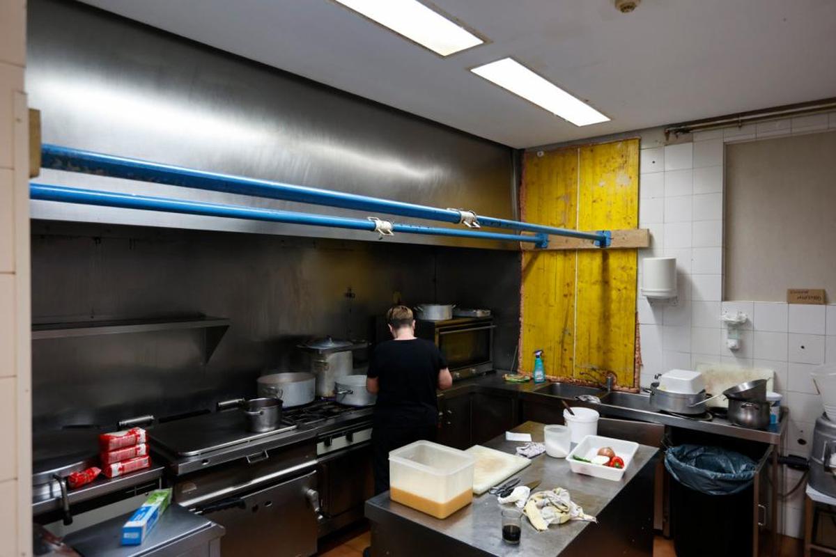 Una persona del equipo de la residencia Aula Rector trabajando en la cocina apuntalada