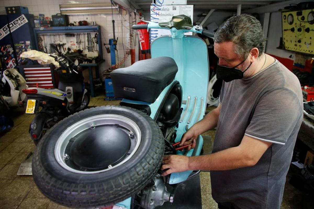 Un trabajador, durante su jornada laboral en su taller de motos