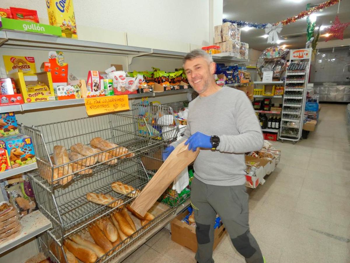 Miguel Ángel Nieto prepara el pan para un cliente en su supermercado de Macotera.