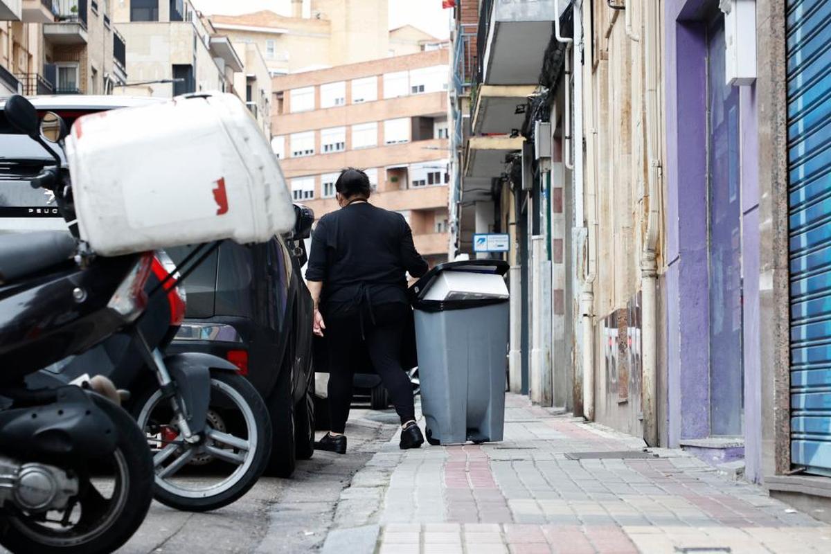 Una mujer tira de un contenedor de basura en la calle Melchor Cano, en el barrio del Oeste. ALMEIDA