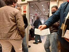Un viajero muestra su billete sin asiento al estar completo en el tren entre Madrid y Salamanca