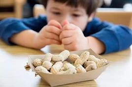 Un niño comiendo cacahuetes