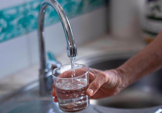 Sirviendo agua del grifo en un vaso.