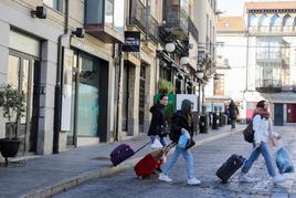 Tres jóvenes salen de un apartamento turístico en el centro de Salamanca.