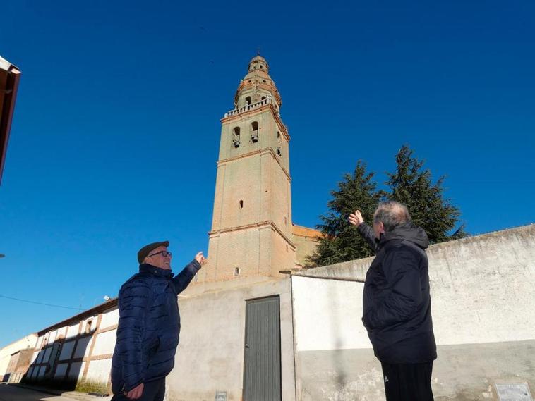 El señor Quico y José Carlos García señalan la parte más deteriorada de la torre de la iglesia de Palaciosrubios
