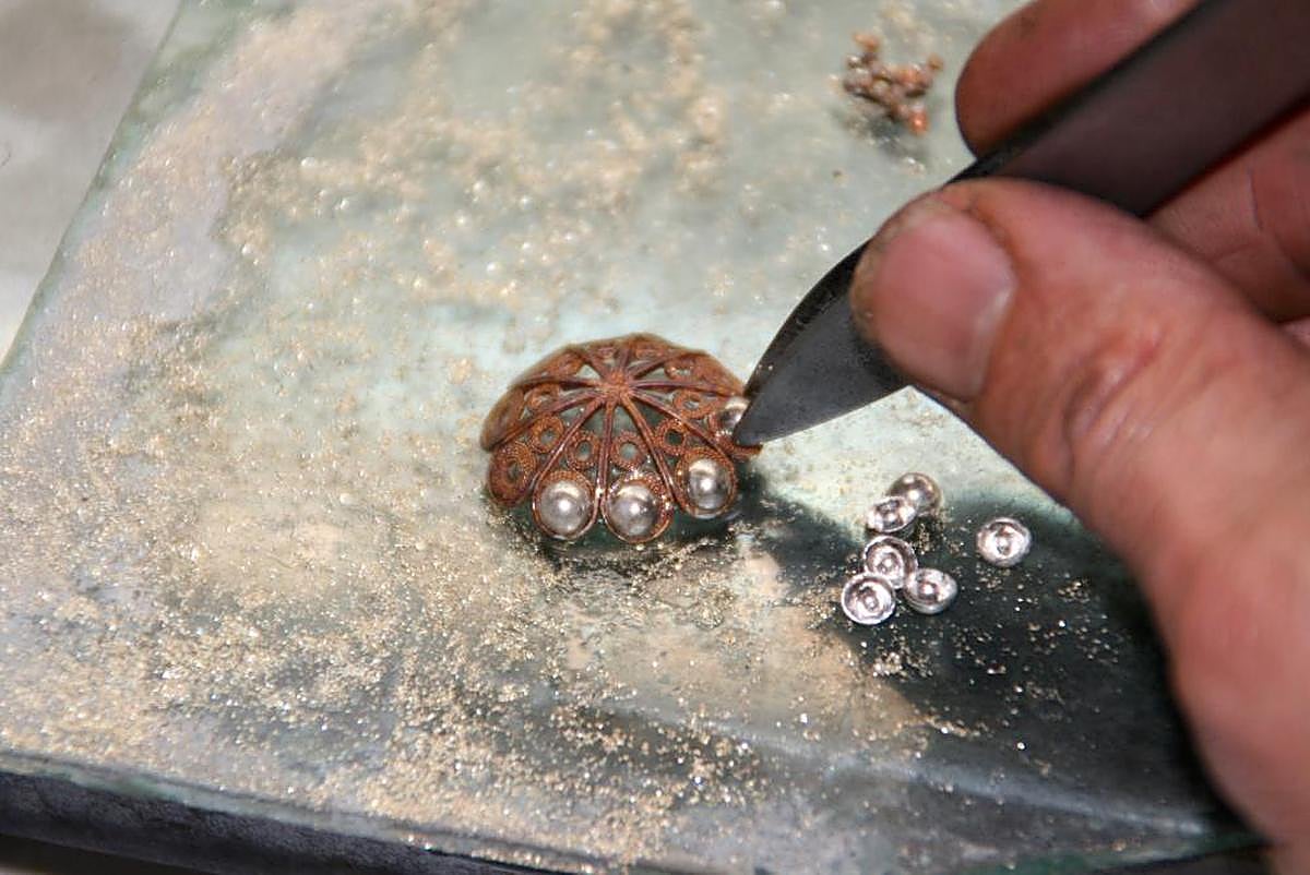 El artesano coloca las casquillas durante el proceso de creación de un botón charro.