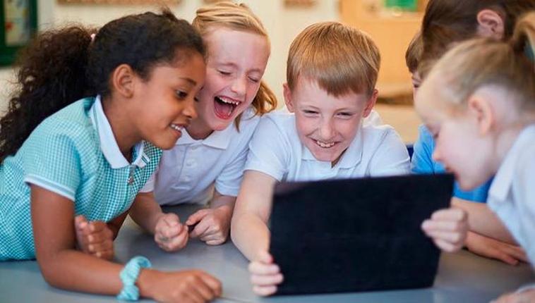 Varios niños se aglutinan frente a una tablet.