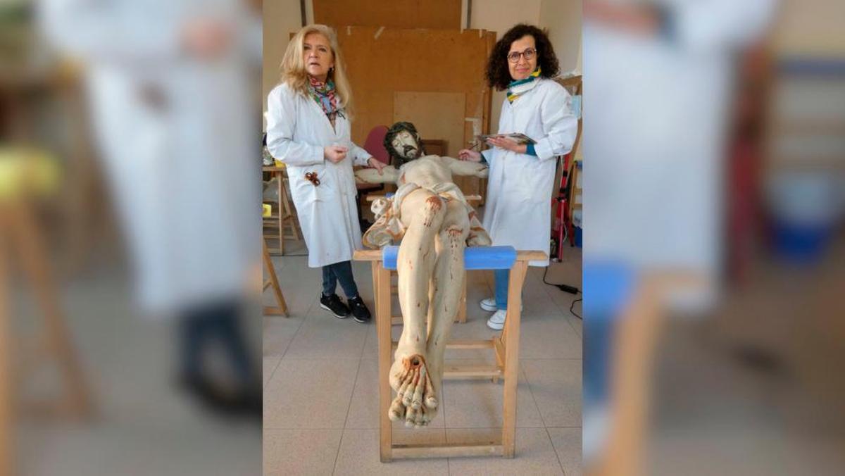 Las restauradoras Carmina Fernández y Carmen Diego dan los últimos retoques al Cristo