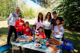 Una familia disfruta de una mesa repleta de hornazo, empanadas y dulces.