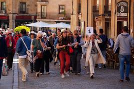 Un grupo de turistas recorre la ciudad con una guía turística.