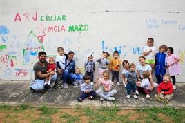 Los más pequeños se divierten pintando un mural en Ciudad Jardín.