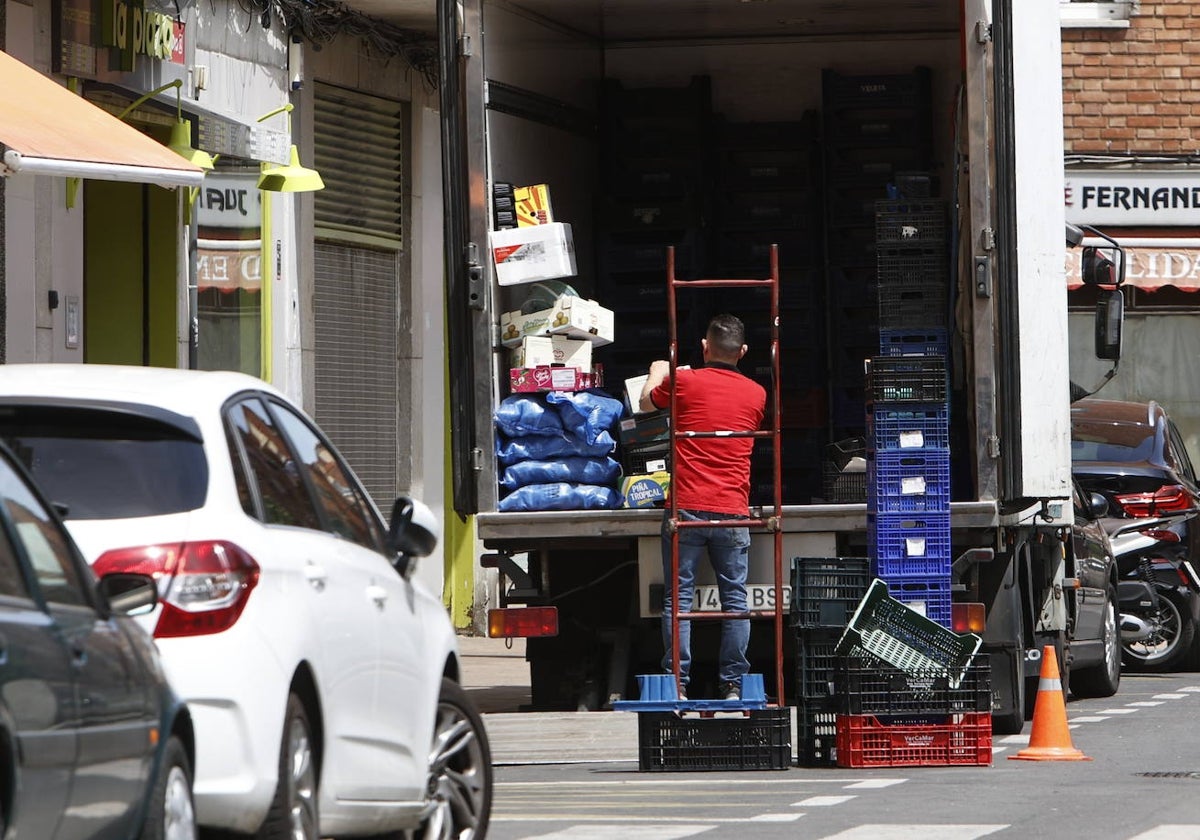 Un montador descarga un camión en plena calle.