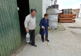 El empleado municipal ayuda a una vecina a llevar el agua a su casa.