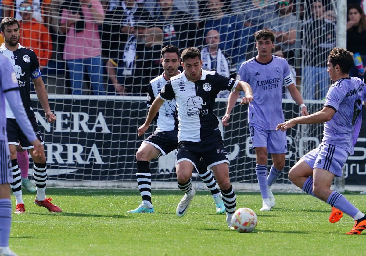 Nespral pugna por un balón ante el canterano del Castilla, Mario, mientras Ramiro le cubre las espaldas.