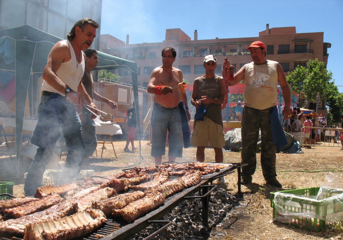 Voluntarios hacen una barbacoa en el barrio de El Zurguén.