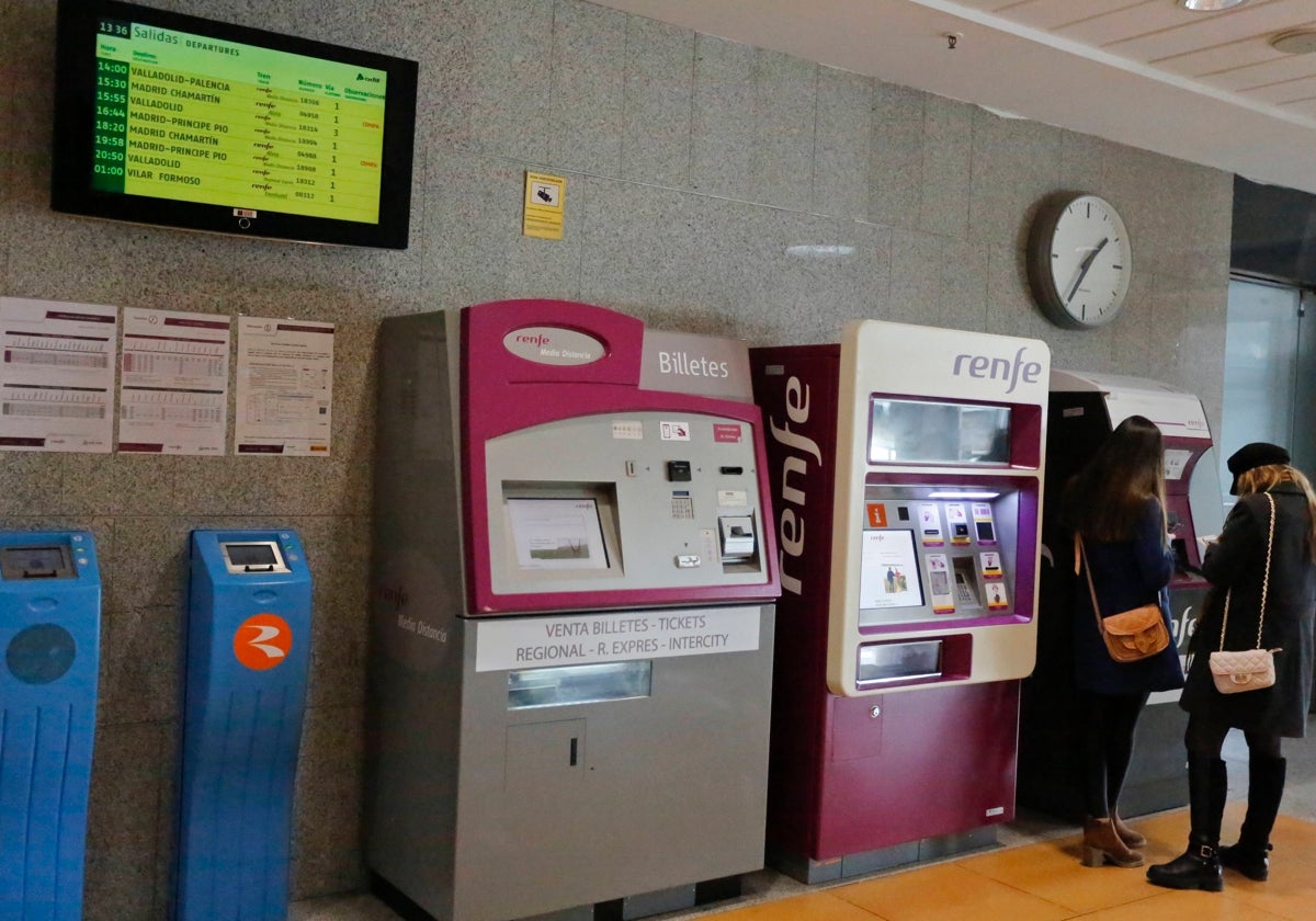 Dos jóvenes adquiriendo un billete de tren en la estación de tren de Salamanca.