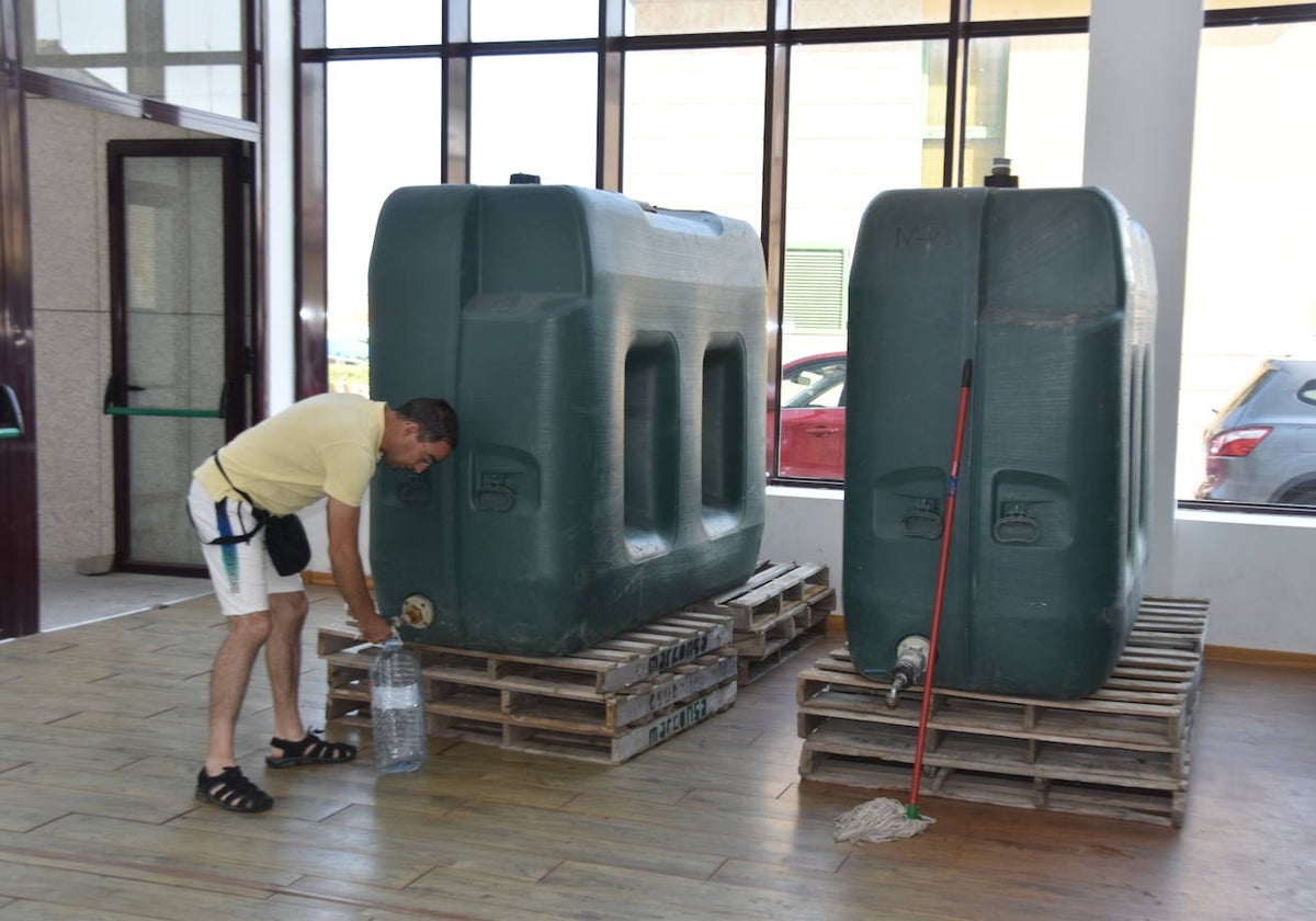 Un vecino de Ledesma, días atrás, recogiendo agua de los depósitos instalados en el Auditorio