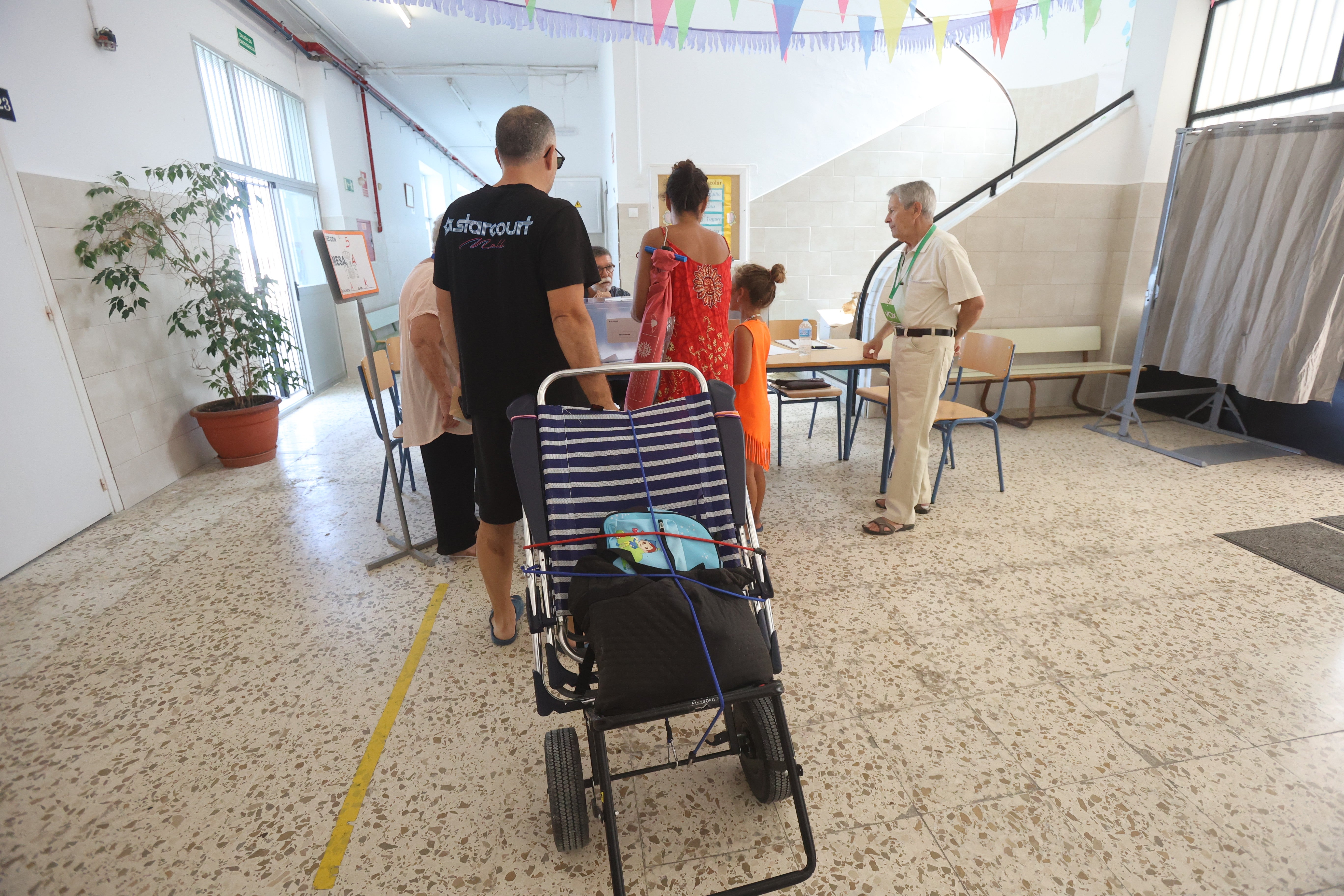 Votantes con tumbonas y chanclas en Cádiz