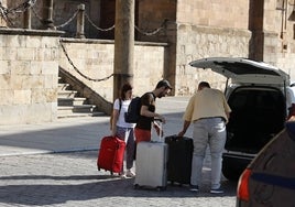 Dos turistas bajan de un taxi tras llegar a Salamanca.